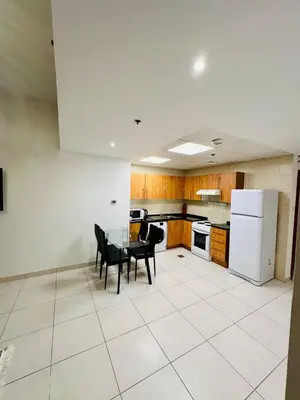 a kitchen with a table and chairs and a refrigerator at Marina View Towers - Dubai Marina Walk Access - View - 1BHK - Marsa in Dubai