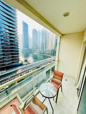 a balcony with chairs and a table and a view of a city at Marina View Towers - Dubai Marina Walk Access - View - 1BHK - Marsa in Dubai
