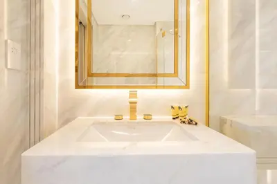 a white bathroom with a sink and a mirror at PVH - Burj Khalifa View Studio - Emaar Residences in Dubai