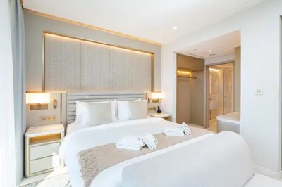 a bedroom with a large white bed with towels on it at PVH - Burj Khalifa View Studio - Emaar Residences in Dubai