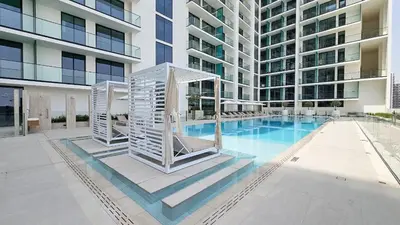 a large apartment building with a swimming pool at StayShort - Perfect Studio in Binghatti Azure JVC - Sleeps 2 in Dubai