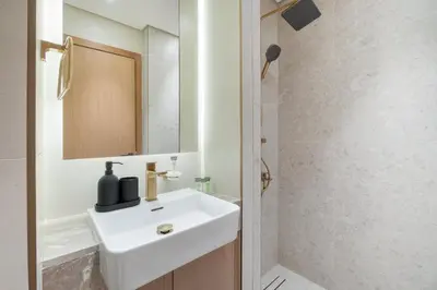 a bathroom with a white sink and a mirror at StayShort - Perfect Studio in Binghatti Azure JVC - Sleeps 2 in Dubai