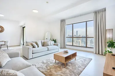 a living room with white furniture and a large window at Modern 3BR in Rimal 5, JBR Dubai in Dubai