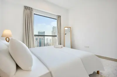 a bedroom with a white bed and a large window at Modern 3BR in Rimal 5, JBR Dubai in Dubai