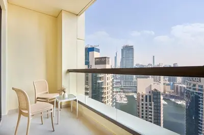 a balcony with chairs and a table and a view of the city at Modern 3BR in Rimal 5, JBR Dubai in Dubai