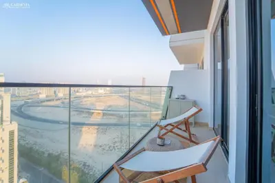 a balcony with a chair and a view at Modern Brand New 1BR Luxury Apartment With Cozy Interiors In Jumeirah Village Circle in Dubai