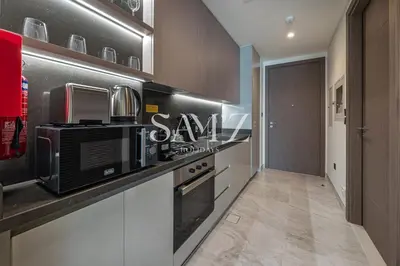 a kitchen with a black and white counter top at Chic Studio Unit 1808 Peninsula Five in Sabkhah