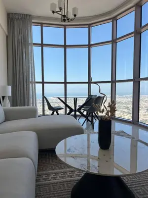 a living room with a table and a large window at 1BR Amazing Dubai And Sea View in Dubai