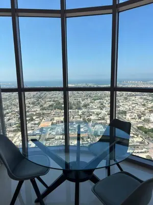 a glass table and two chairs in front of a window at 1BR Amazing Dubai And Sea View in Dubai