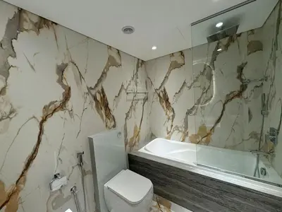 a bathroom with a tub and a toilet and a sink at Full Lake View spacious 2 bdr apartment, Metro in Dubai