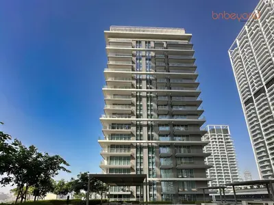 a tall apartment building with two tall buildings at Private Beach Access with Luxury Beachfront Lifestyle in Dubai