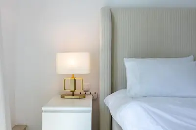 a bedroom with a bed and a lamp on a night stand at Modern Luxury Marina Stay with Ain Dubai View - Near JBR Beach in Dubai