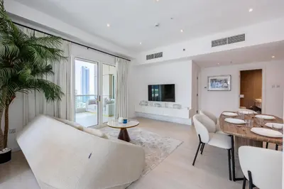 a living room with a couch and a table and chairs at Modern Luxury Marina Stay with Ain Dubai View - Near JBR Beach in Dubai