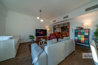 a living room with a couch and a tv at Waterfront 1BR Apartment At Heart of Dubai Marina in Dubai