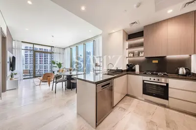 a kitchen and dining room with a table and chairs at Sleek 1BR Gem - Unit 1709 - Peninsula Five in Dubai