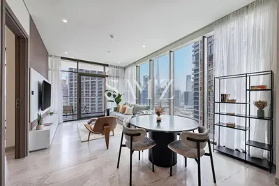 a living room with a table and chairs and a large window at Sleek 1BR Gem - Unit 1709 - Peninsula Five in Dubai