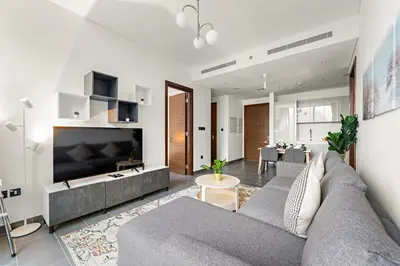 a living room with a gray couch and a table at FIRST CLASS 2BR Luxury Hideaway in Dubai