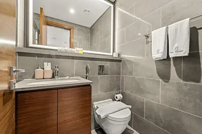 a bathroom with a toilet and a sink and a mirror at FIRST CLASS 2BR Luxury Hideaway in Dubai