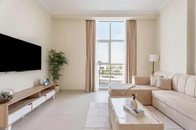 a living room with a couch and a flat screen tv at Chic 1BR w Pool Sauna & Steam Room Access in Dubai