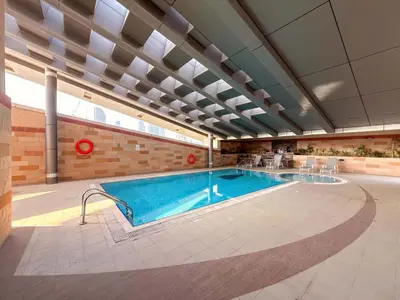 a large swimming pool in a building at Chic 1BR w Pool Sauna & Steam Room Access in Dubai