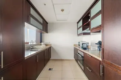 a large kitchen with wooden cabinets and a sink at FIRST CLASS 1BR Downtown Luxury in Dubai