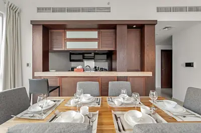 a dining room with a table and chairs and a kitchen at FIRST CLASS 1BR Downtown Luxury in Dubai