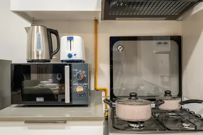 a kitchen with a microwave and a stove top oven at FIRST CLASS 1BR Relaxing Vibes in JVC in Dubai