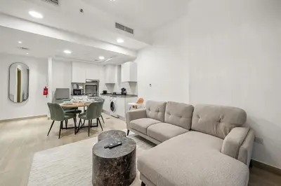 a living room with a couch and a table at FIRST CLASS 1BR Relaxing Vibes in JVC in Dubai