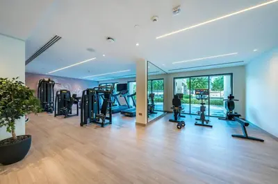 a gym with several treadmills and ellipticals in a room at Stunning 2BR- Burj Royale 411 - Burj Khalifa View in Dubai