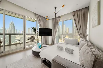 a living room with a bed and a large window at FIRST CLASS 2BR Burj and Fountain Cozy Luxe in Dubai