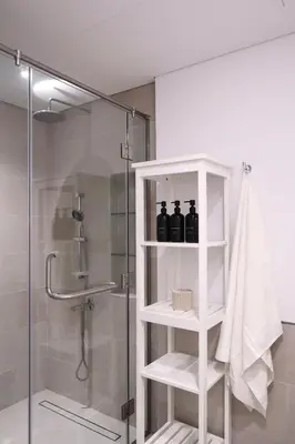 a bathroom with a shower with three bottles on a shelf at Madinat Jumeirah Living in Dubai