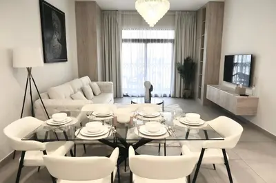 a living room with a glass table and white chairs at Madinat Jumeirah Living in Dubai
