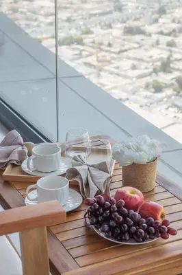 a table with cups and plates of fruit on a table at Frank Porter - Aykon City 2 Tower C in Dubai