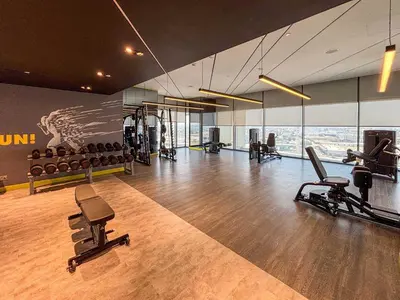 a gym with treadmills and chairs in a room at Frank Porter - Aykon City 2 Tower C in Dubai