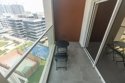 a balcony with a table and chairs in a building at FIRST CLASS Studio Chic and Comfy in Jewelz in Dubai