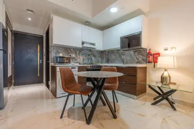 a kitchen with a table and chairs in a kitchen at FIRST CLASS Studio Chic and Comfy in Jewelz in Dubai