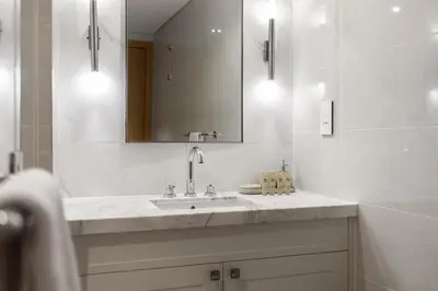 a white bathroom with a sink and a mirror at Maison Privee - City Heights Retreat with Panoramic Skyline Views in Dubai