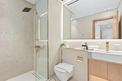 a bathroom with a toilet and a sink and a shower at FIRST CLASS 1BR Elegant Living with City Views in Dubai