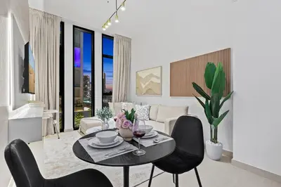 a living room with a table and chairs at FIRST CLASS 1BR Elegant Living with City Views in Dubai