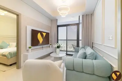 a living room with a blue couch and a bed at Vogue Business Bay Aykon City Tower Close to Downtown Burj Khalifa and Dubai Mall, Two Bedroom Apartment with Large Balcony Sea view, Access to all Amenities in Dubai