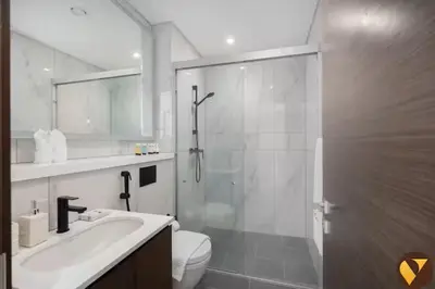 a bathroom with a shower and a toilet and a sink at Vogue Al Maktoum City Sobha Hartland The Crest Near to Downtown, Burj Khalifa and Dubai Mall, Three Bedroom plus Kid's room apartment with Balcony and City View, Access to all Amenities in Dubai
