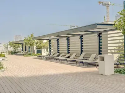 a row of white lounge chairs in a building at Vogue Al Maktoum City Sobha Hartland The Crest Near to Downtown, Burj Khalifa and Dubai Mall, Three Bedroom plus Kid's room apartment with Balcony and City View, Access to all Amenities in Dubai