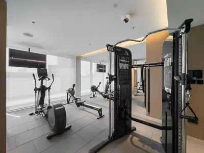 a gym with several tread machines and a mirror at Vogue Al Maktoum City Sobha Hartland The Crest Near to Downtown, Burj Khalifa and Dubai Mall, Three Bedroom plus Kid's room apartment with Balcony and City View, Access to all Amenities in Dubai
