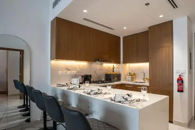 a kitchen with a bar with chairs and a counter top at Airstay - Modern 1BR - Pool Views - Azizi 61 - Monthly Offer Available in Dubai