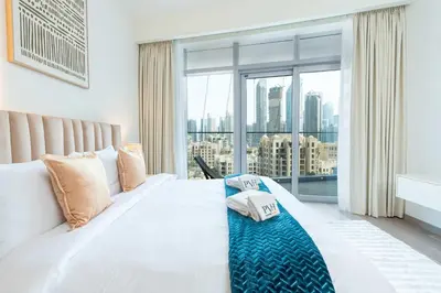 a bedroom with a large bed with a large window at PVH - 1BR with Burj Khalifa View - Imperial Avenue in Dubai