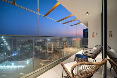 a balcony with chairs and a view of a city at FIRST CLASS 1BR Modern Serenity , Near Downtown in Dubai