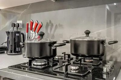 two pots on top of a stove in a kitchen at FIRST CLASS 1BR Modern Serenity , Near Downtown in Dubai