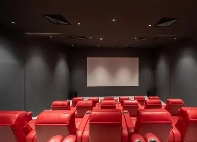 a cinema room with red chairs and a screen at FIRST CLASS 1BR Modern Serenity , Near Downtown in Dubai