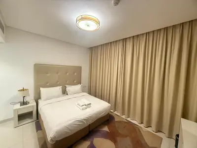 a bedroom with a large white bed and a window at Wecation- Chic 2BR Damac Maison Cour Jardin Business Bay in Dubai