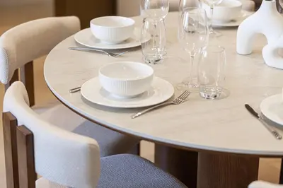 a table with white plates and glasses on it at Full Burj Khalifa And Fountains View Exclusive 2BR Luxury Apartment In The Heart Of Downtown Dubai in Dubai